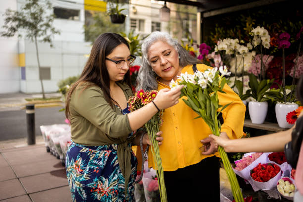 istock Mother and daughter buying flowers 1363603247