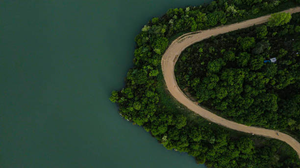 vista aerea viaggio su strada attraverso un bosco, strada sterrata tra foreste in riva al lago, vista natura di sfondo, vista su strada aerea, vista aerea su lago e strada, percorso a piedi sul lago, percorso di trekking sul lago, fotografia di sfondi - yalova foto e immagini stock