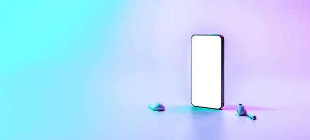 istock Mockup device. Mobile smart phone technology blank screen. Mock up audio headphones equipment on neon gradient background. Game design, smartphone application presentation or portfolio mockups. 1363606218
