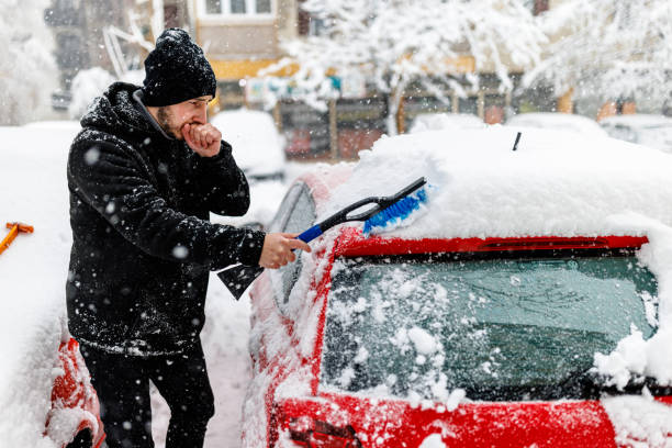 istock A Young Man is Cleaning Snow from a Car with a Brush. 1363612140