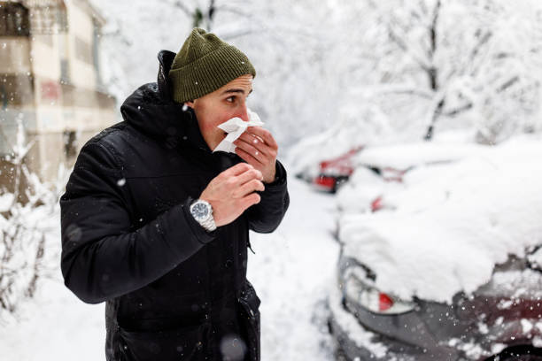 istock Young Man is Blowing a Nose During a Winter Day. 1363613779