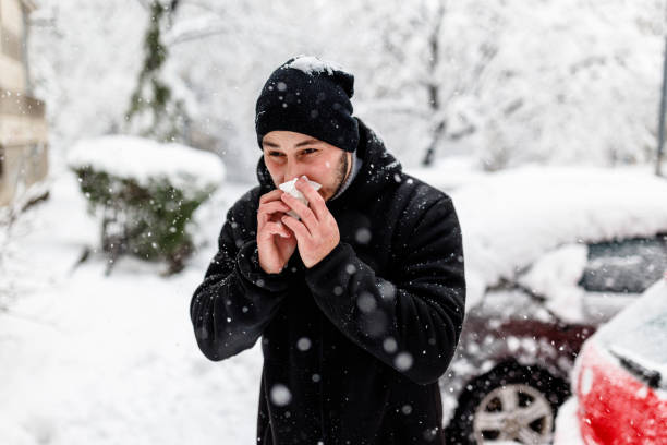 istock Young Man is Blowing a Nose During a Winter Day. 1363613791