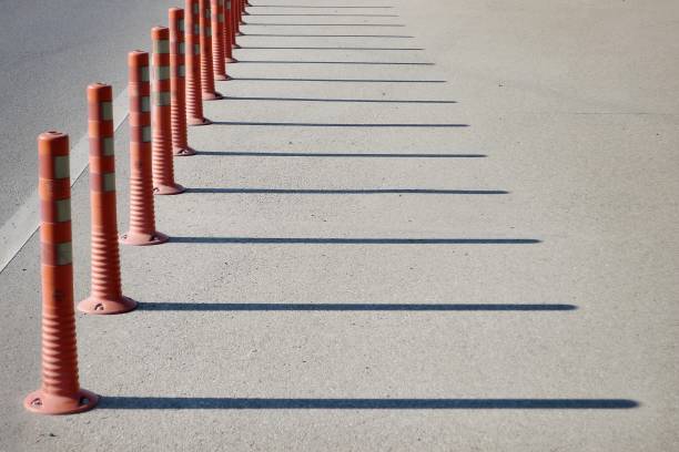 istock Red regilation poles throwing shadows on the road. 1363614159