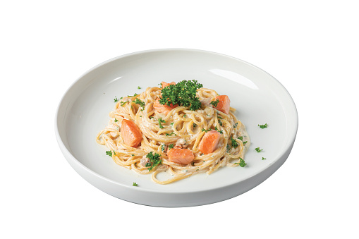 spaghetti with salmon on a white plate