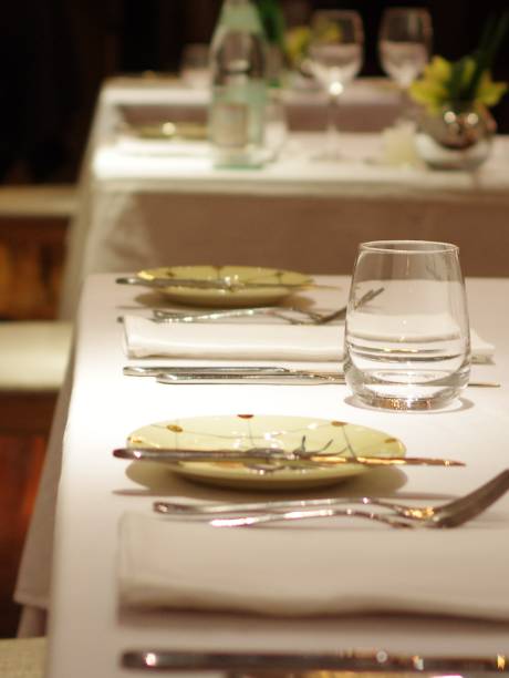 istock Empty drinking glass wineglasses and stainless steel tableware on white tablecloth with napkin at fine dining restaurant 1363616678