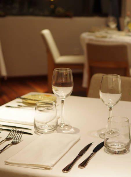 istock Empty drinking glasses crystal wineglasses and stainless steel tableware on white tablecloth with napkin at fine dining restaurant 1363616714