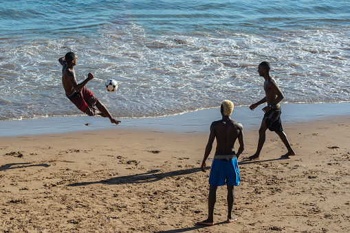 Salvador, Bahia, Brazil - January 08, 2020: Young people playing sand football on the beach of Ondina in the afternoon sun. Salvador Bahia Brazil.