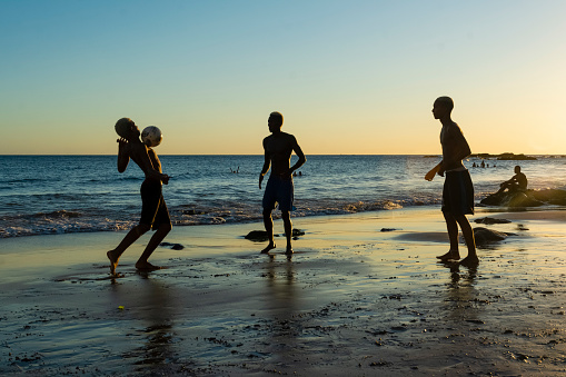 Salvador, Bahia, Brazil - January 08, 2020: Young people playing sand football at sunset on Ondina beach in Salvador, Bahia, Brazil.