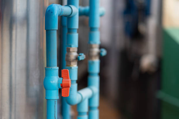 Valve of the plumbing pipeline system. Opened valve of the plumbing pipeline system, flowing to the water storage tank. Industrial object photo. Close-up and selective focus at the front valve. faucet leaking pipe water stock pictures, royalty-free photos & images