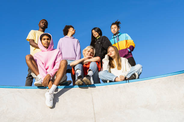 Multiracial group of young friends bonding outdoors Multicultural group of young friends bonding outdoors and having fun - Stylish cool teens gathering at urban skate park cool attitude fashion stock pictures, royalty-free photos & images