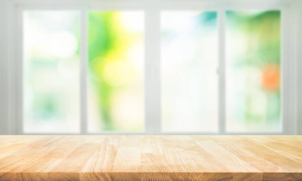 istock Empty wood table top on blur abstract green garden from window view. 1363626422