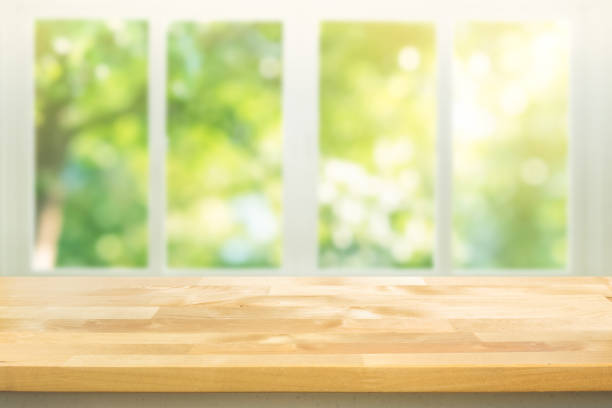 istock Empty wood table top on blur abstract green garden from window view. 1363626438