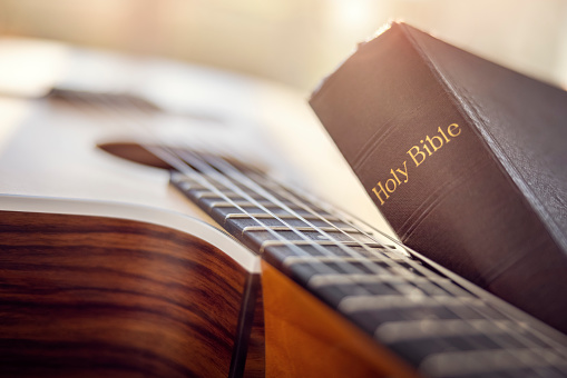 Holy Bible with acoustic guitar, gospel music concept