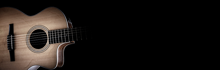 Acoustic guitar and blank black background hear or banner with copy space