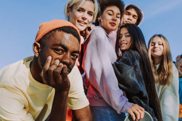 groupe multiracial de jeunes amis se liant à l’extérieur - secteur de la mode photos et images de collection