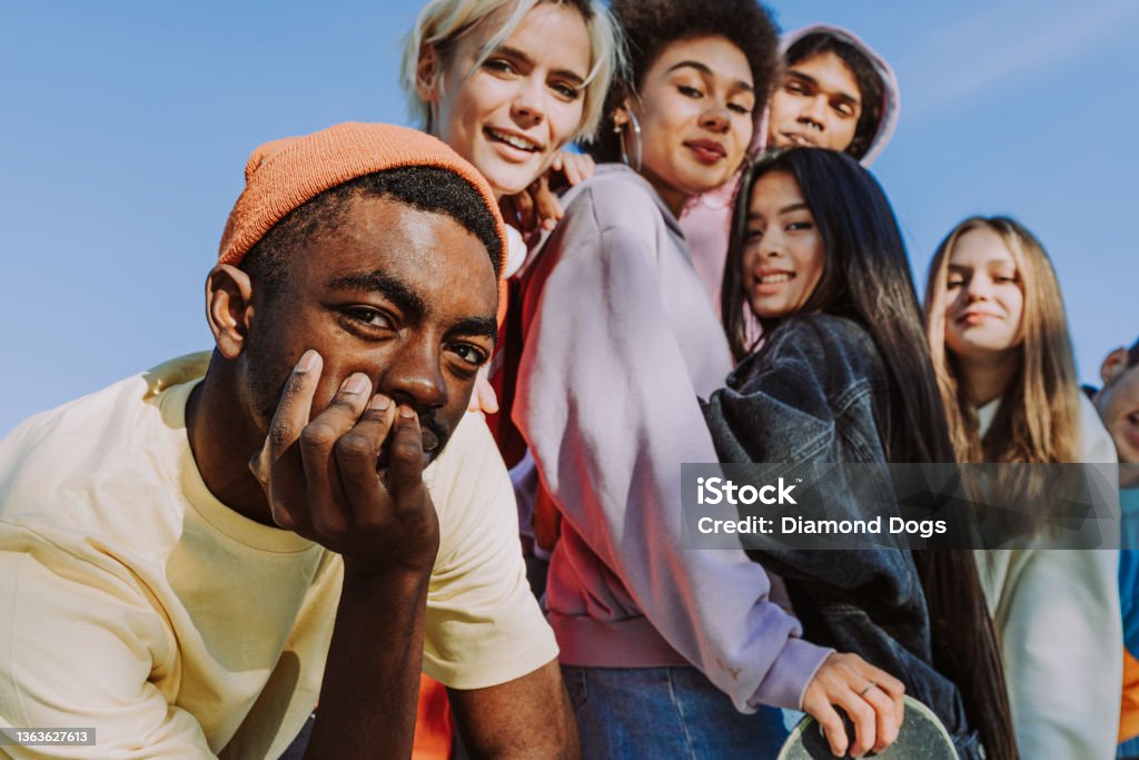 Multiracial group of young friends bonding outdoors Multicultural group of young friends bonding outdoors and having fun - Stylish cool teens gathering at urban skate park Teenager Stock Photo