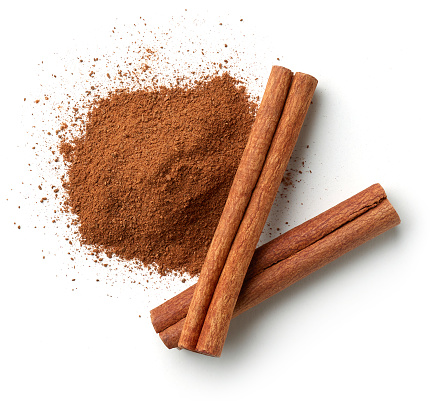Cinnamon sticks and heap of powder isolated on white background