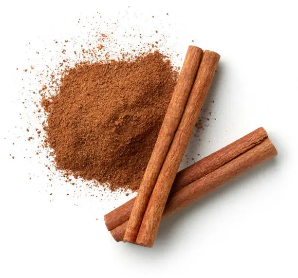 Photo of Cinnamon sticks and heap of powder isolated on white background