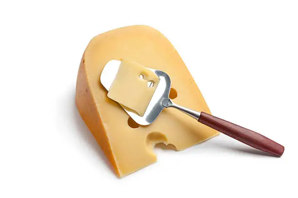 Piece of Dutch farmers cheese with a cheese-slicer on white background