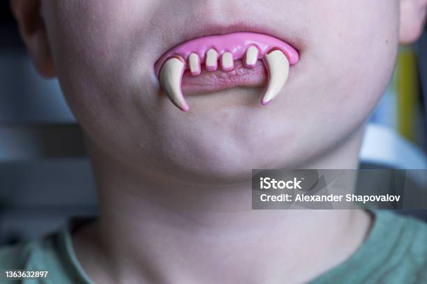 Close Up View Of Toy Vampire Teeth In Childs Mouth Halloween Prank