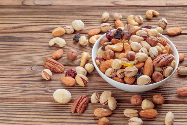 istock Mixed nuts on wooden background. Walnut, pistachios, almonds, hazelnuts and cashews. Selective focus 1363637654