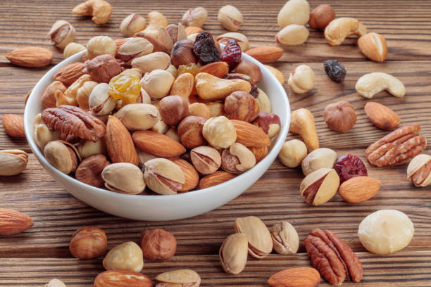 istock Mixed nuts on wooden background. Walnut, pistachios, almonds, hazelnuts and cashews. Soft focus. 1363637661