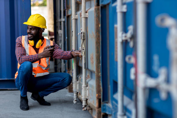 istock Foreman holding walkie- talkie for control working at Container cargo site. Handheld walkie talkie for outdoor 1363638055