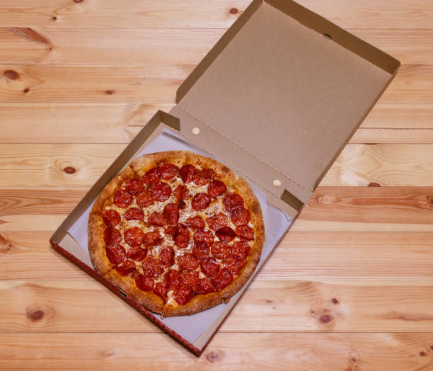 istock Pepperoni pizza in box on wooden  table. 1363638942