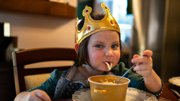 giovane bambina che mangia zuppa al tavolo. - two girls only cheerful front view horizontal foto e immagini stock