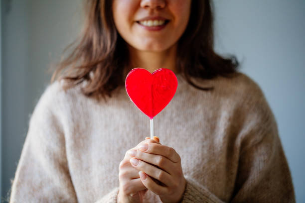 istock Beautiful Woman Holding Heart Shape Candy 1363642926