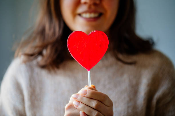 istock Beautiful Woman Holding Heart Shape Candy 1363643056