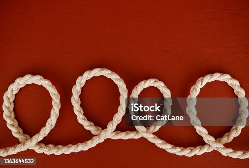 istock Red background with coils of braided string 1363644532