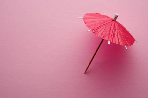 czerwony parasol koktajlowy izolowany na różowym tle. - decorative umbrella zdjęcia i obrazy z banku zdjęć