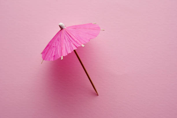 parapluie cocktail rose isolé sur fond rose. - drink umbrella umbrella pink paper photos et images de collection