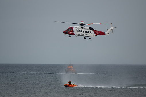 Withernsea, UK - August 20 2017\n\nUK Coastguard Helicopter practises rescue manoeuvres with RNLI Humber Lifeboat and RNLI Withernsea Inshore Rescue Lifeboat