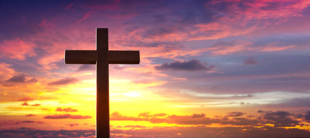 istock Silhouette of crucifix cross at sunset sky. 1363649318