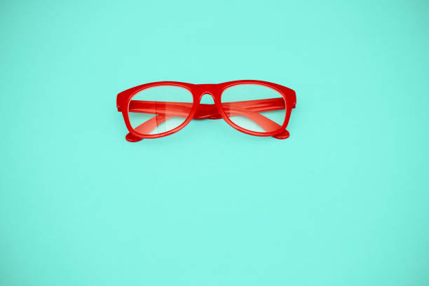 istock Pair of modern red eyeglasses on a green background with space for copy 1363652564