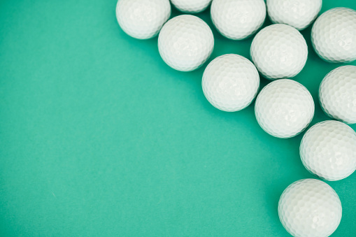 Background pattern made out of white golf balls on a vibrant teal background