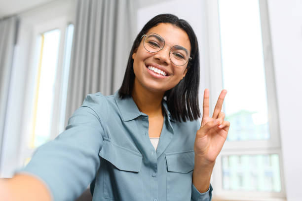 istock Young and energetic multiracial female making selfie or having video call, while spending time at home and waving at the camera, saying hello. Job hunting 1363654244