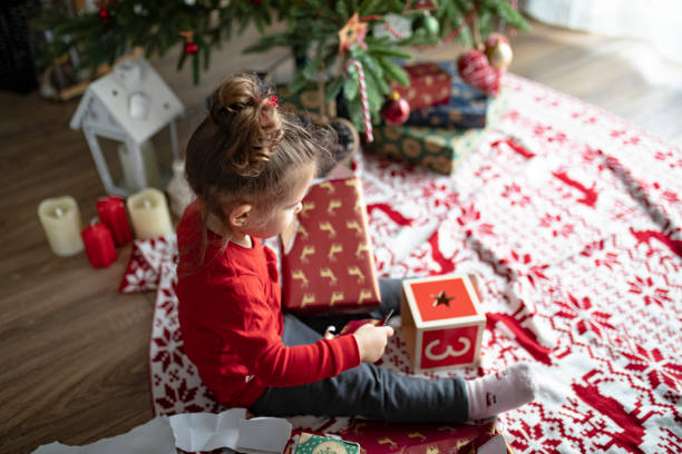istock Surprised cute child girl opening a Christmas present 1363654576