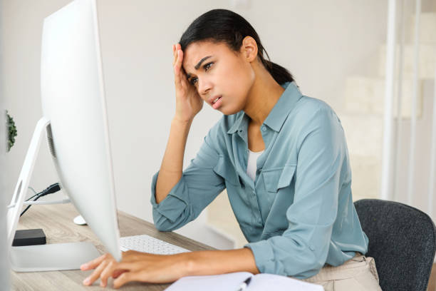 istock Mixed-race female freelancer or student sitting on the couch, feeling tired from work on computer, touching temple, having headache and cannot concentrate 1363654605