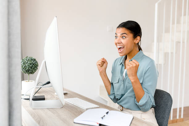 istock Female student using app for distance video communication, studying online, taking courses while staying at home. Girl looking at laptop screen and rejoicing 1363654670