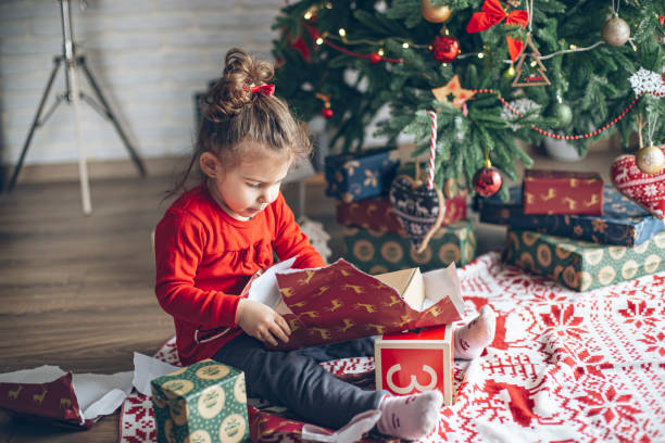 istock Surprised cute child girl opening a Christmas present 1363655656