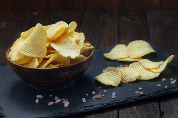 istock Crispy potato chips in a wooden bowl on old kitchen table 1363656395
