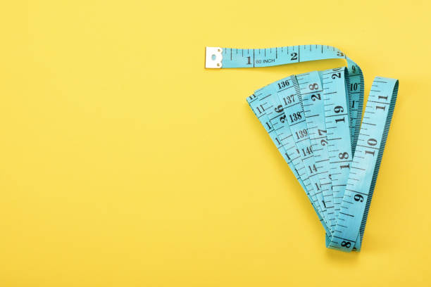 istock Tape measure on the yellow background with copy space 1363658317