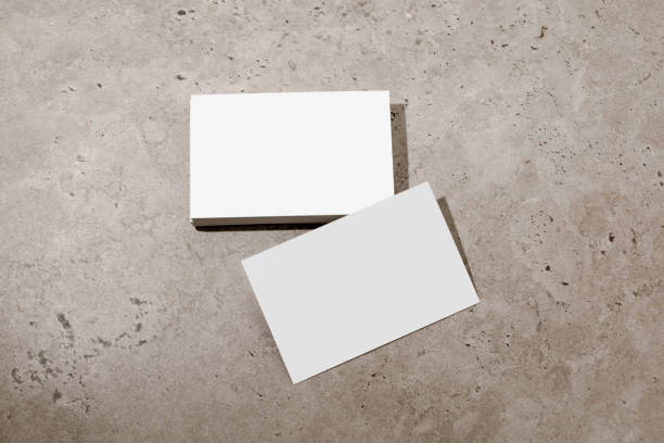 Blank white business cards on rough concrete surface. Mockup for branding identity. Possibility to show both sides of card. Template for graphic designers. Free space, copy space.