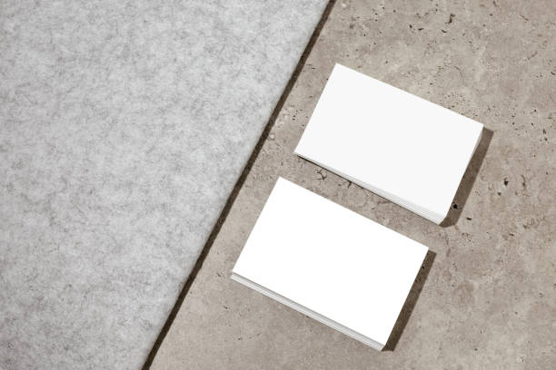istock Blank white business cards on rough concrete surface. Mockup for branding identity. Two stacks, to show both sides of card. Template for graphic designers. Free space, copy space. 1363659478