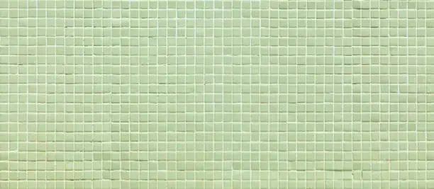 Photo of Small light green tiles background, full frame view.