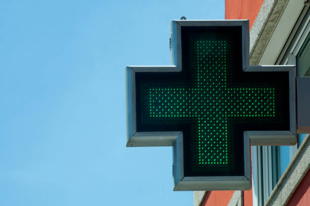 istock Pharmacy symbol and green cross, clear blue sky background. 1363660033