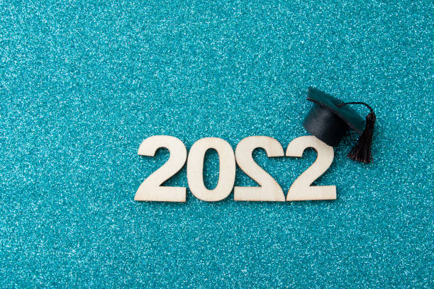 istock Graduat hat with wooden number 2022 on blue glittering background. Education, leaning, class 2022 concept 1363661465
